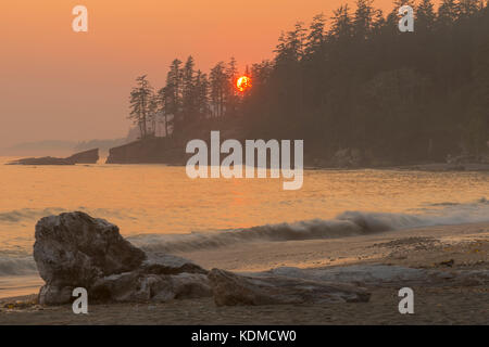 Smoke from the BC wild fires fill the sky during sunset at Tsusiat Falls on the West Coast Trail in Pacific Rim National Park Stock Photo