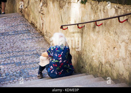Czechia old women sitting lonely at pathway of Prague castle on August 31, 2017 in Prague, Czech Republic Stock Photo