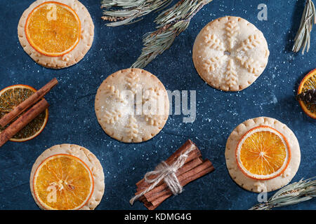 Top view of mince pies, baked crumbly pastry packed with plump, juicy vine fruits, tangy peel and spices. Concept of Christmas baking. Stock Photo