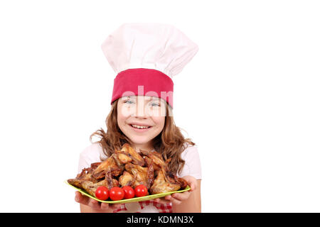 happy little girl cook with roasted chicken wings on plate Stock Photo