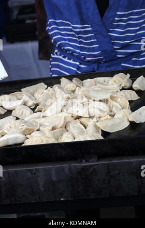 Asian Dumplings being cooked on a hot plate Stock Photo