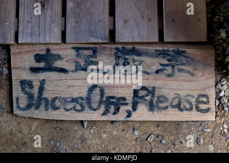 Kyoto, Japan -  May 20, 2017: Entrance to a Japanese temple with a sign to take your shoes off as respect and tradition Stock Photo