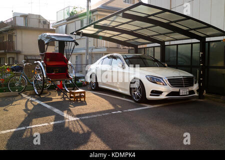 Kyoto, Japan - May 21, 2017: Rickshaw and mercedes car together parked in the street showing old compared to new transport Stock Photo