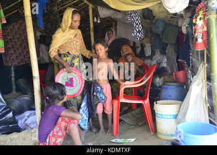A Rohingya family member sits in makeshift house at the Balukhalicmakeshift Camp in Cox's Bazar, Bangladesh, on October 10, 2017. According to the U Stock Photo