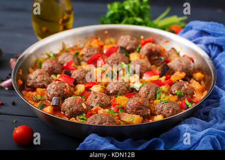 Meatballs in tomato sauce and vegetables in stew-pan Stock Photo