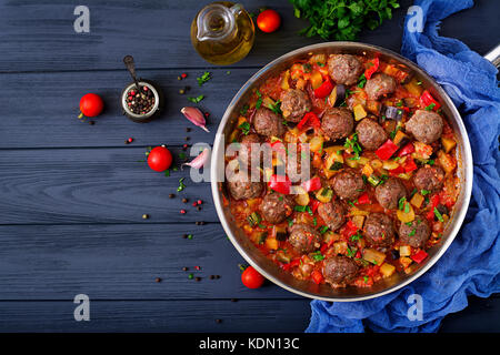 Meatballs in tomato sauce and vegetables in stew-pan Stock Photo