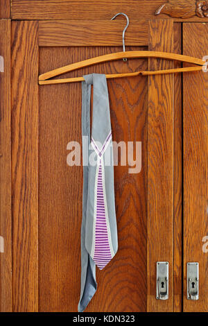 Vintage necktie hangs on a hanger on wardrobe door Stock Photo