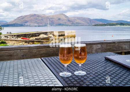 Two printed half-pint glasses of Belhaven beer on a table overlooking Loch Linnhe, Hollytree Hotel, Kentallen, Glencoe, Argyll and Bute, Scotland Stock Photo