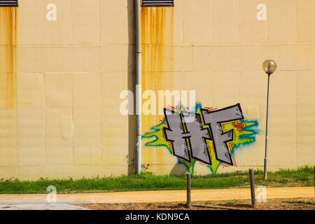 Colourful and artistic graffiti on a cream plastered wall in Albuferia in Portugal Stock Photo