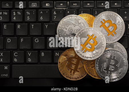Bitccoin coins are lying on a laptop keyboard Stock Photo