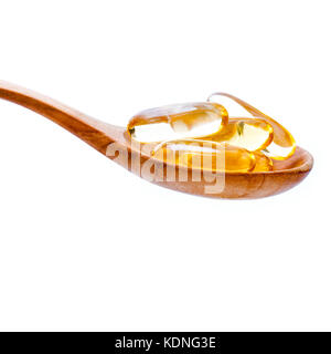 Spoonful of gel capsules of omega 3. Close up capsules fish oil in wooden spoon .The supplement high vitamin E, omega 3 and DHA . Capsules fish oil wi Stock Photo