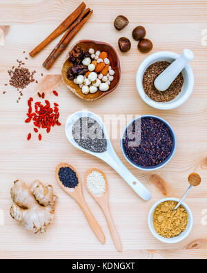 Nutritious Foods and Super foods selection with supplement powders in mortar and spoons setup on wooden background. Chia seeds ,flex seeds ,ginger ,ri Stock Photo