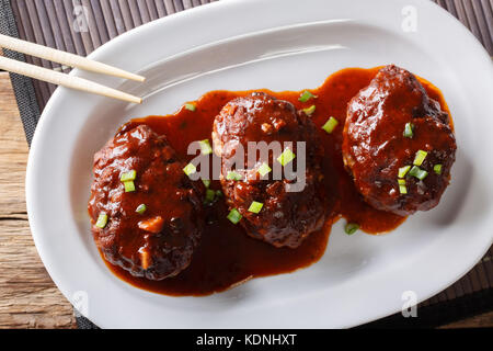 Japanese food: hamburg steak or hambagu with a spicy sauce on a plate close-up. horizontal top view from above Stock Photo
