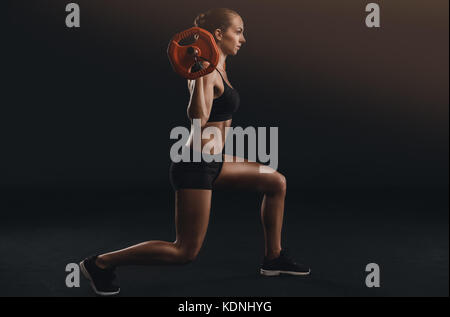 Shot of a beautiful young woman in a workout gear lifting weights Stock Photo