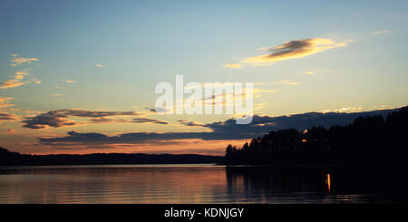 Sunset on the Kenozero lake. Calm summer evening. Natural background. Wide format photo. Kenozersky National Park (UNESCO Biosphere Reserve), Russia. Stock Photo