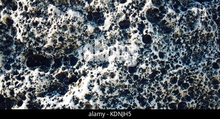 Magma background. Toned photo. Wide format. Porous rock texture. Black and white foamypumice. Foamy stone texture. Closeup shot of lava stone. Walking Stock Photo