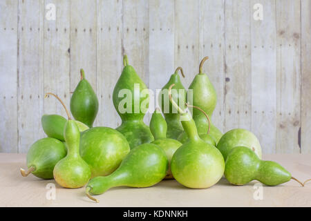 Pile of freshly harvested green bottle gourds on wood background Stock Photo