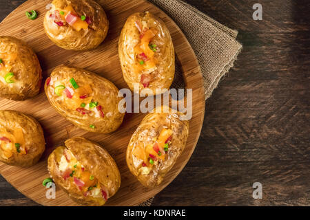 Baked potatoes with cheese, bacon, and copy space Stock Photo
