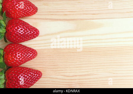 Vibrant Red Fresh Ripe Strawberry Fruits Lined up on Wooden Table, with Free Space for Design or Text Stock Photo