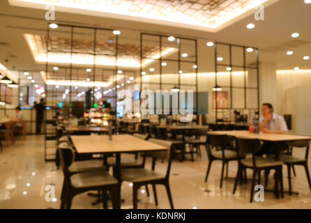 Blurred modern style interior of a cafe restaurant in beige and black color with many lighting Stock Photo