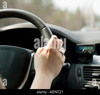 A woman's hand on the steering wheel of the car Stock Photo