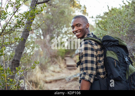 Smiling young African man hiking in the hills Stock Photo