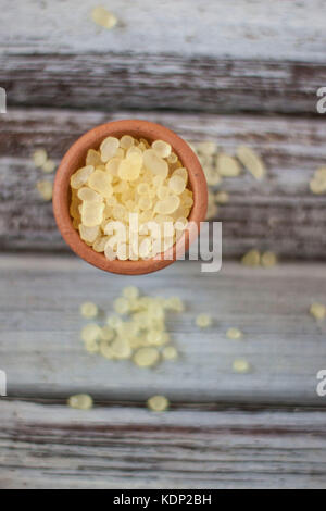 Mastic gum on clay bowl over rustic wooden background Stock Photo