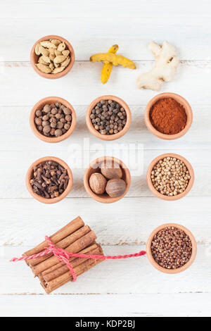 Spices for ras-el-hanout, morrocan spice mixture, all separated in clay bowls on rustic whitish background Stock Photo