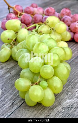 Ripe white and red grapes on a wooden background. Stock Photo