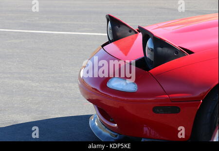 Pop up headlights on a red Mazda Miata. Stock Photo