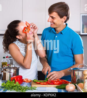 Happy couple cooking veggies stew in domestic kitchen Stock Photo