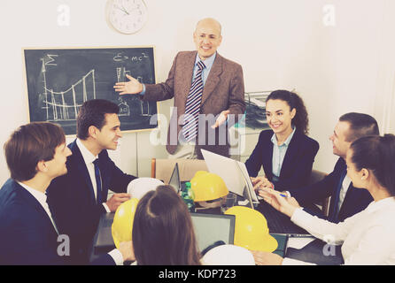 Happy multinational team of architects brainstorming in office Stock Photo