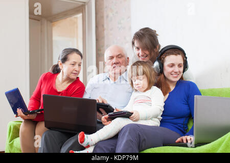 family of three generations uses few various devices in home Stock Photo