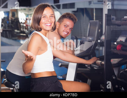 Young cheerful woman spinning bicycle on weight loss training in gym Stock Photo