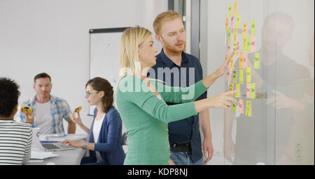 Two coworkers brainstorming on scheme Stock Photo