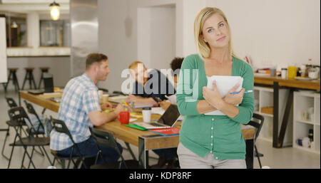 Confident woman in office with coworkers Stock Photo