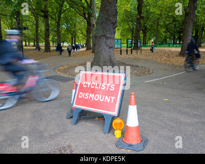 Cyclists ignore the sign that instructs them to dismount from their bicycles Stock Photo