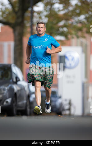 Osnabrueck, Germany. 13th Oct, 2017. Scottish long-distance runner John McGurk runs at a Volkswagen production site in Osnabrueck, Germany, 13 October 2017. A charity run to five different VW-productions sites starts on 15 October 2017 in Osnabrueck. The group will reach VW-headquarter Wolfsburg on 17 October 2017. The aim is to raise 100,000 Euros for poor children in Berlin and India. The 500 kilometer run is part of the terre des hommes challenge 'How far would you go?', on the occasion of the 50th anniversary of the children aid organization. Credit: Friso Gentsch/dpa/Alamy Live News Stock Photo