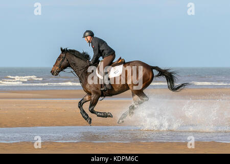 Southport, Merseyside, Sunny in Southport. 15th October 2017. UK Weather.  Greg Mook rides his 13 year old horse 'Monty' through the shallow tide on a gorgeous warm & sunny day at Southport in Merseyside.  Credit: Cernan Elias/Alamy Live News Stock Photo