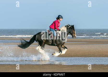 Southport, Merseyside, Sunny in Southport. 15th October 2017. UK Weather.  13 year old Liv Douglas rides her 7 year old horse 'Oliver' through the shallow tide on a gorgeous warm & sunny day at Southport in Merseyside.  Credit: Cernan Elias/Alamy Live News Stock Photo