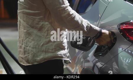 Young man fueling his car at gas station Stock Photo