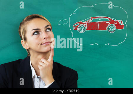 Young Beautiful Businesswoman Thinking To Buy A Car Against Blackboard Stock Photo