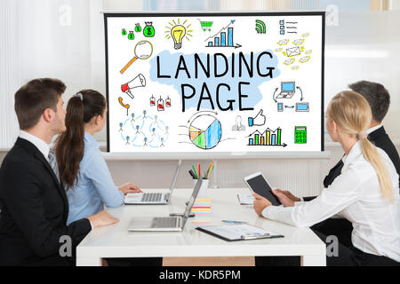 Businesspeople Looking At Landing Page Concept On Projector Screen In Conference Room Stock Photo