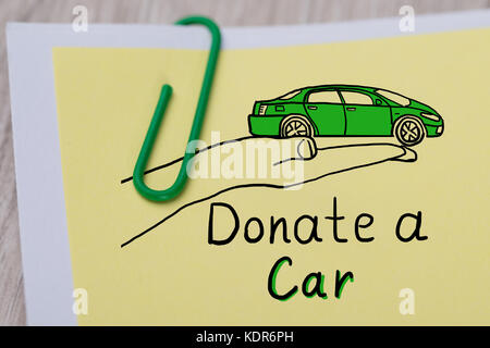 Close-up Of Concept Of Car Donation Text Written On Note Paper Attached With Paper Clip Stock Photo