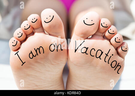 Close-up Of Person Feet With Handwritten Text And Smile Face On All Ten Toes Stock Photo