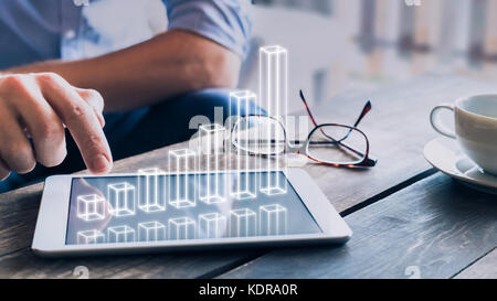 Businessman analyzing growing 3D AR chart floating above digital tablet computer screen, showing successful increase in business profit Stock Photo