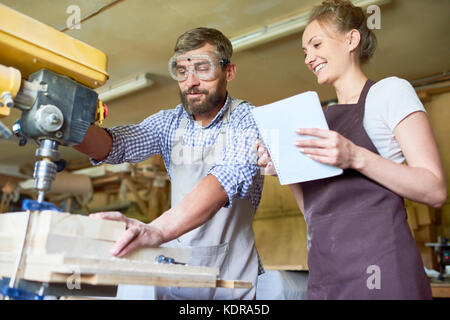 Skilled Carpenter Working with Drilling Machine Stock Photo