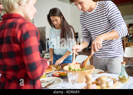 Friends Setting Up Dinner Table Stock Photo