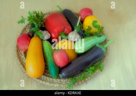 On the table on a wicker platter are a variety of vegetables: cucumbers, eggplants, tomatoes, pumpkins, squash, parsley. Stock Photo