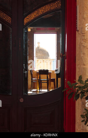 View through the front doors of a hotel in Valletta, Malta, with a vedette or sentrybox on the fortifications visible from a back window Stock Photo